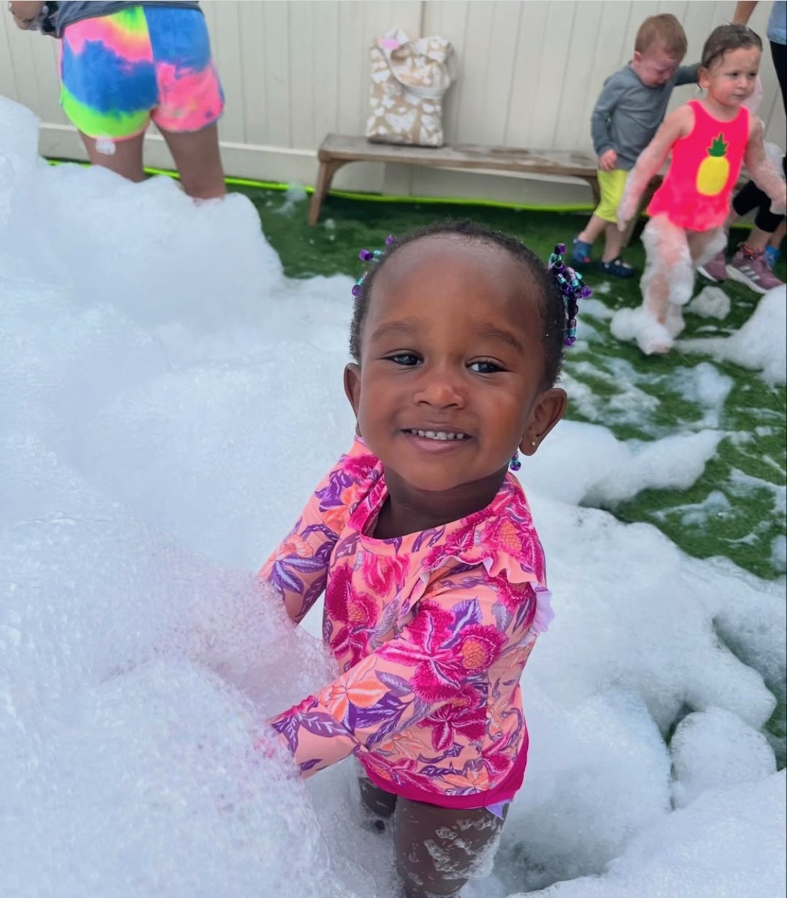 Happy toddler playing in soft foam at a family foam party