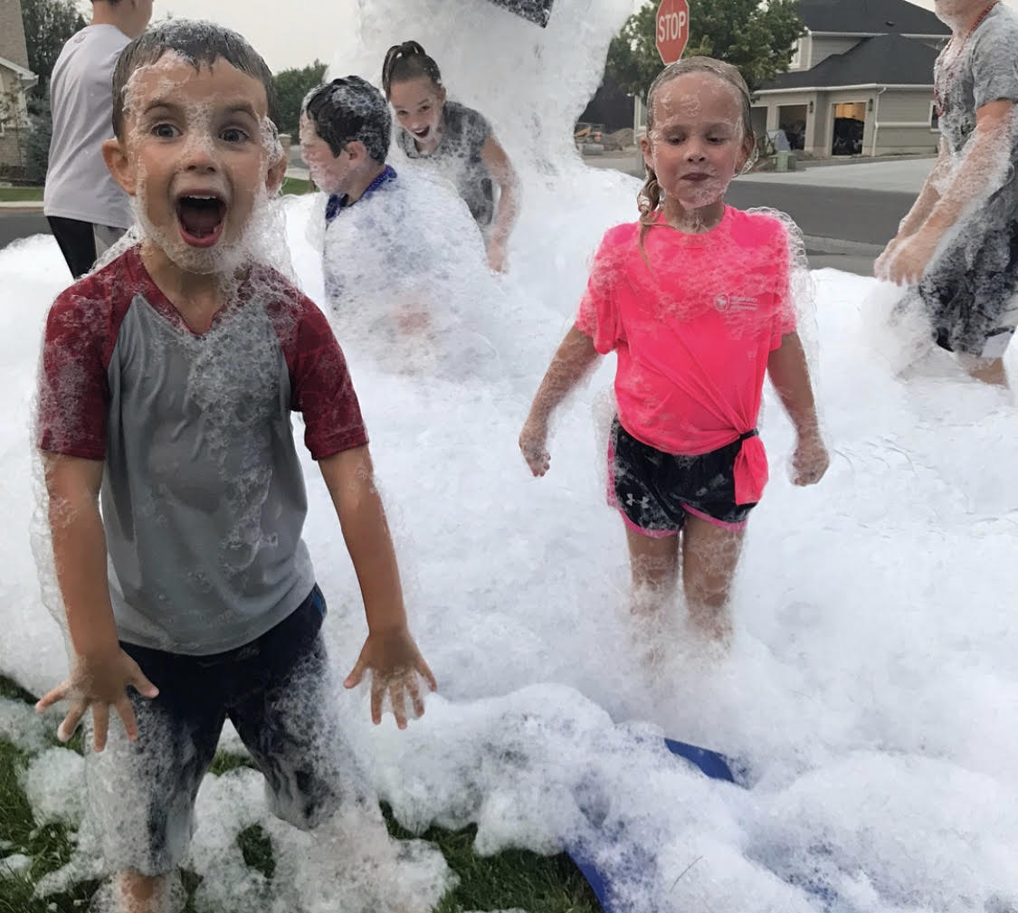 Excited child covered in foam at a neighborhood foam party in Cincinnati