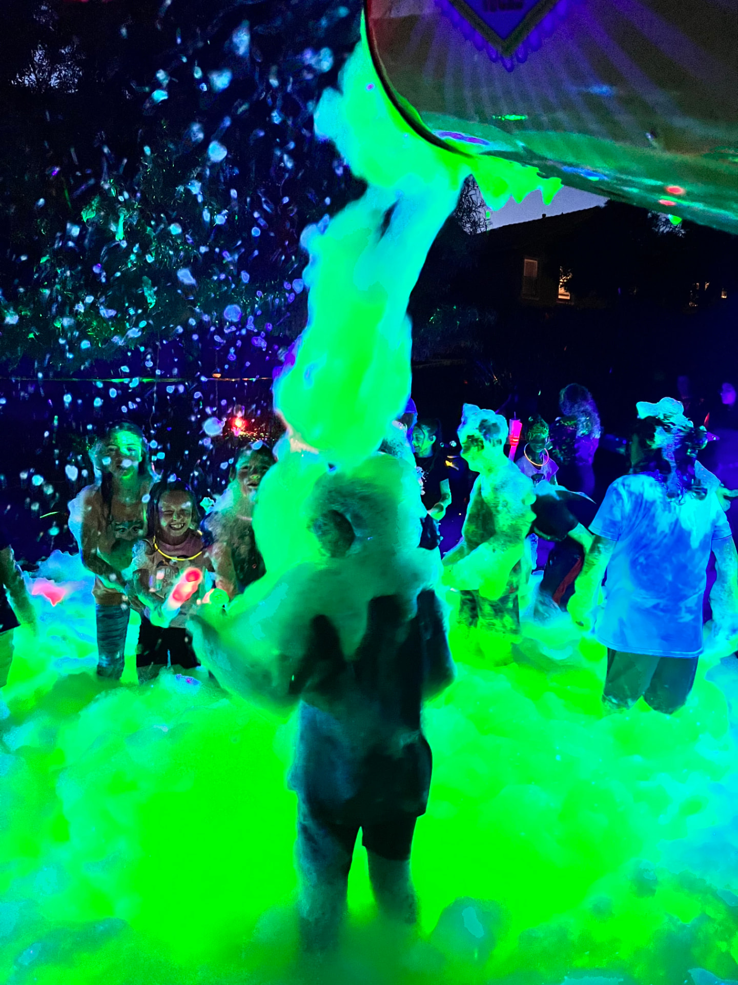 Glow foam party in Cincinnati at night with neon lighting over a crowd